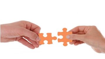 שתי ידיים עם שתי חתיכות פאזל