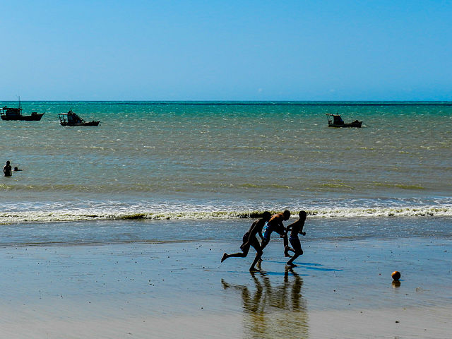 צעירים משחקים כדורגל על החוף בברזיל